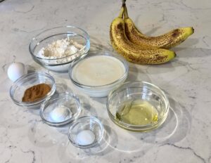 A close up image of the 8 ingredients used to make the banana pancakes