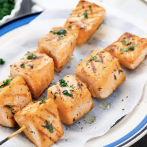 An up close image of salmon skewers on a plate.