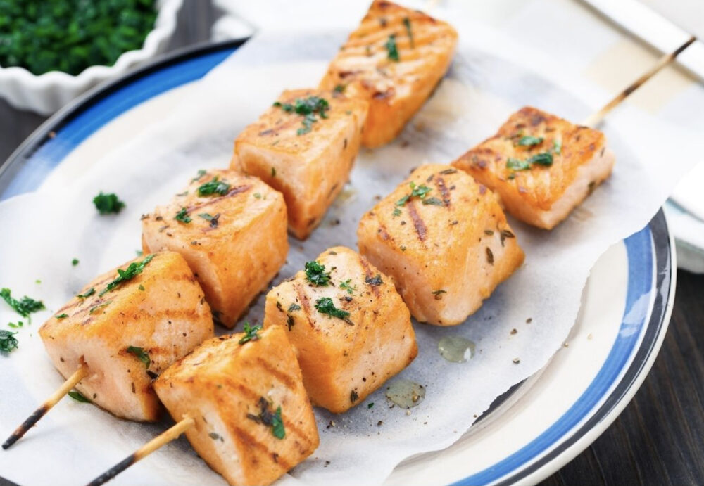 An up close image of salmon skewers on a plate.
