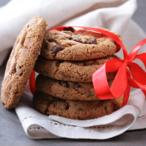 A close up image of anti-inflammatory gingerbread cookies tied in a red ribbon.