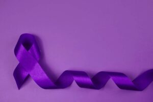 An up close image of a purple ribbon on a purple colored backdrop