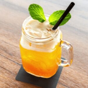 An up close image of a virgin passionfruit mojito drink in a mason jar