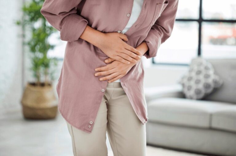 An image of a women clutching her gut in pain